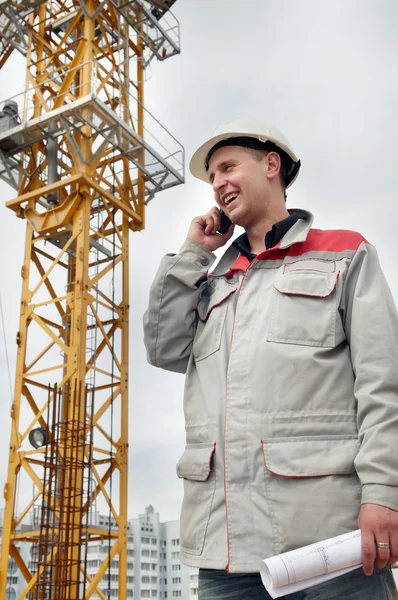Builder at construction site with phone — Stock Photo, Image