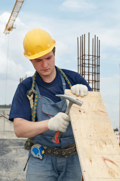 Bauarbeiter arbeitet mit Hammer und Sperrholz — Stockfoto