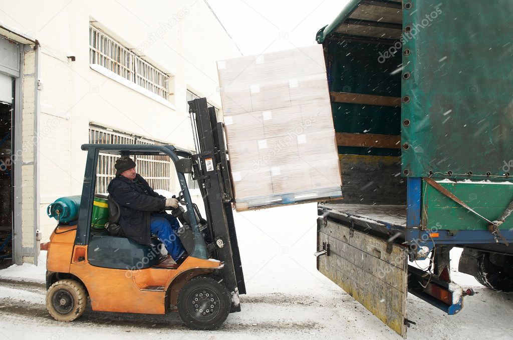 Warehouse forklift loading a car