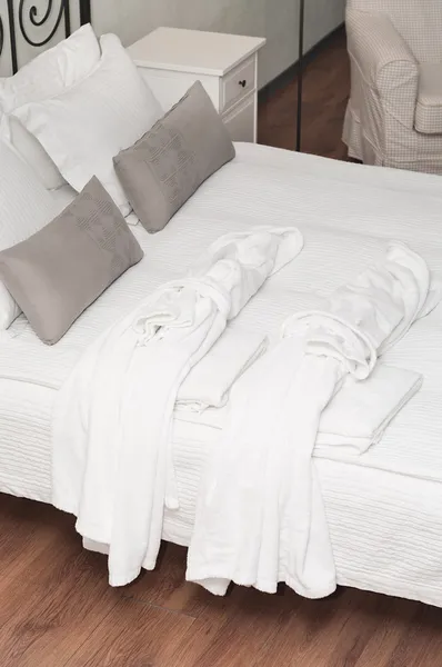 Dois terry vestidos de vestir branco na cama — Fotografia de Stock