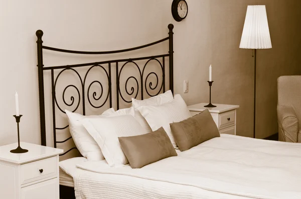 Forged headboard of bed with pillows — Stock Photo, Image