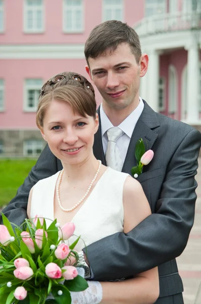 Young loving wedding couple with bunch of flower — Stock Photo, Image