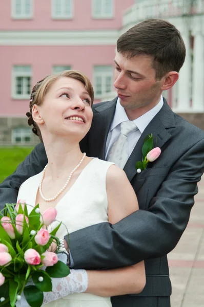 Jeune couple amoureux de mariage avec un bouquet de fleurs — Photo