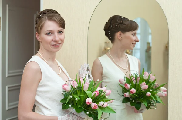 新娘站在镜子旁边一年轻女子 — 图库照片
