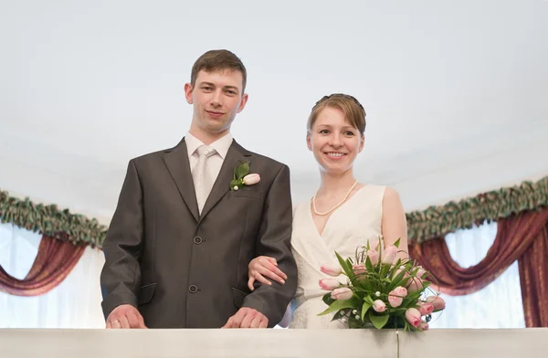 Junges verliebtes Hochzeitspaar mit Blumenstrauß — Stockfoto