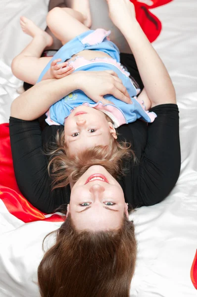 Молодая мать и маленький ребенок лежали на спине — стоковое фото