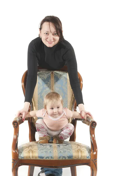 Mladá matka a dcera sedí na židli. — Stock fotografie