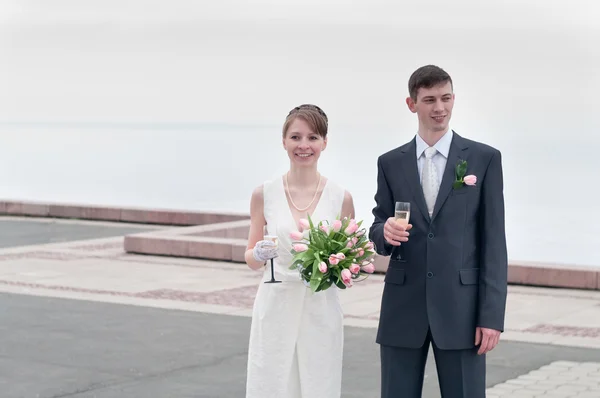 Giovane coppia di nozze amorevole con mazzo di fiori. Coppia di sposi — Foto Stock