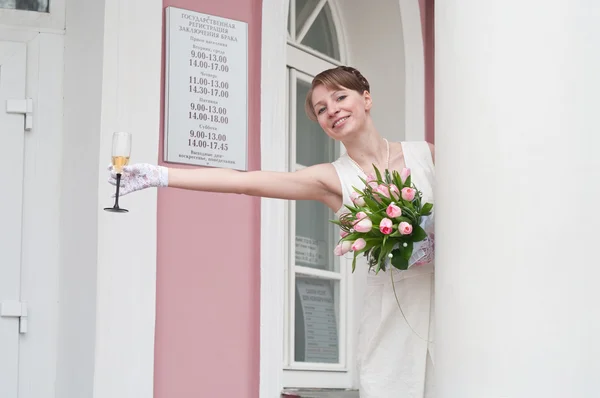 Mujer una novia con una copa de vino cerca de un registro de edificios de oficinas. Tabla es —  Fotos de Stock
