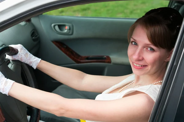 白いドレスと白い手袋をしたドライバーとして車に座っている女性. — ストック写真