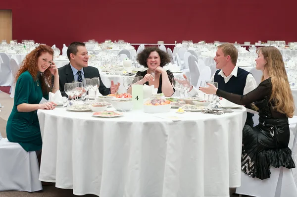 Πέντε νέοι σε στρογγυλό λευκό τραπέζι σε εστιατόριο. — Φωτογραφία Αρχείου