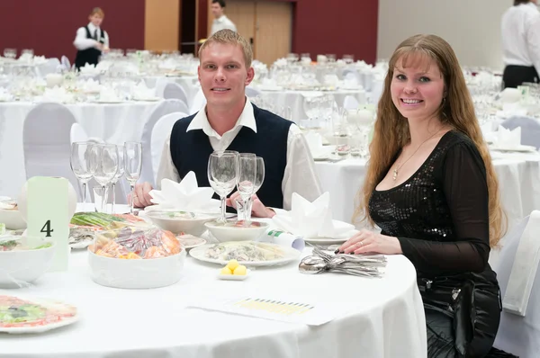 Amante jovem casal no restaurante à mesa branca redonda. Jantar — Fotografia de Stock