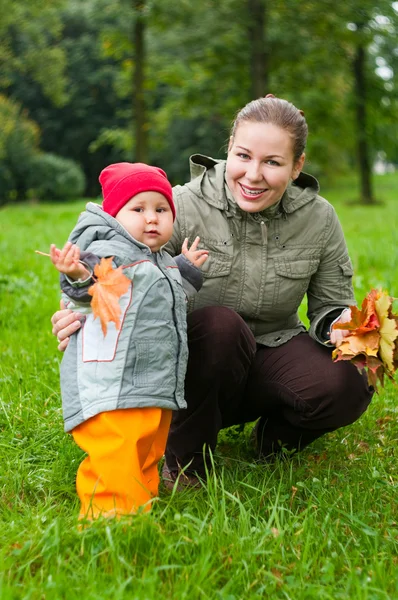 Donna una madre e un bambino che camminano insieme nel parco autunnale — Foto Stock