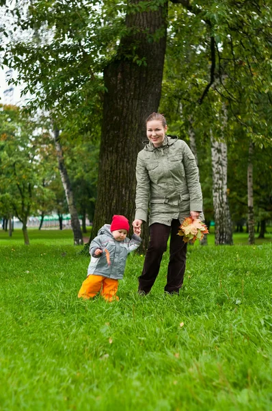 Femme une mère et un petit enfant marchant ensemble dans le parc d'automne — Photo