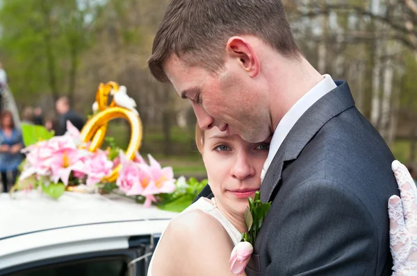 Junges verliebtes Hochzeitspaar mit Blumenstrauß. — Stockfoto