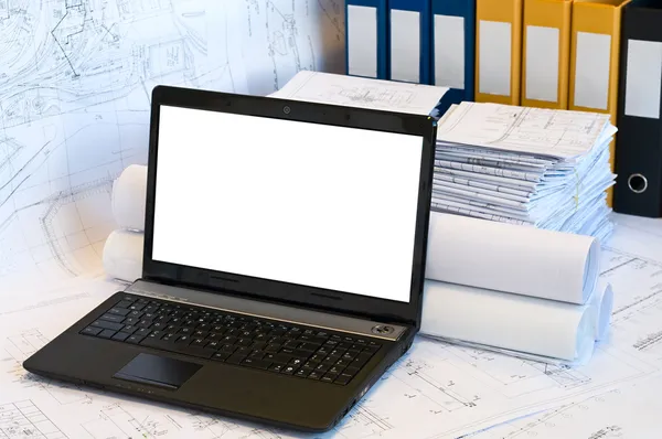 Geopend laptop en stapel van projecttekeningen — Stockfoto