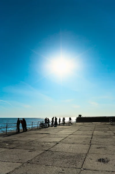 Bright sun on blue sky. Sea coast with — Stock Photo, Image