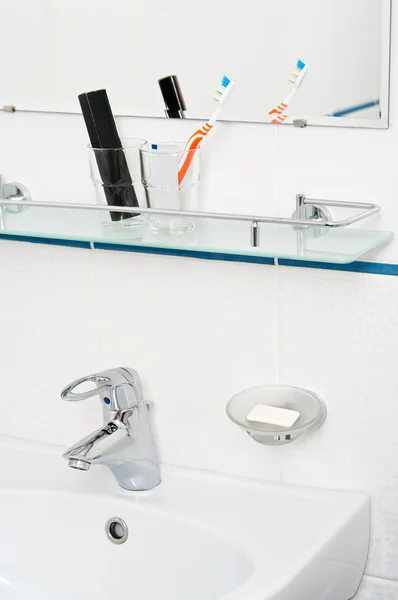 Akcesoria łazienkowe: pasty do zębów i szczotki na półka szklana — Zdjęcie stockowe