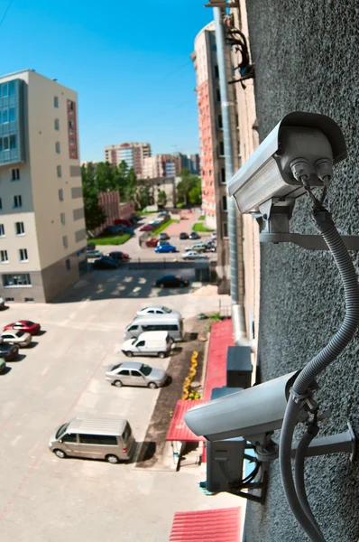 Câmera óptica na parede do prédio assistindo no estacionamento — Fotografia de Stock