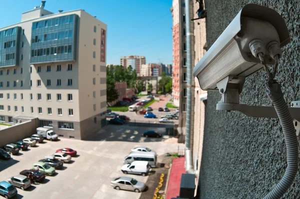 Câmera óptica na parede do prédio assistindo no estacionamento — Fotografia de Stock