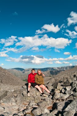 Father and son on peak of mountain. clipart