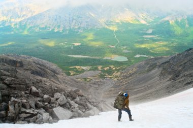 Man standing on peak of mountains clipart