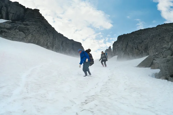 Horolezci chůzi na vrcholu hory na sněhu. — Stock fotografie