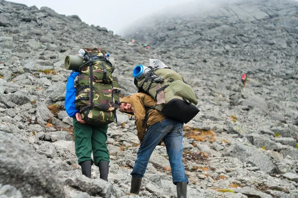 Dos mochileros cansados en las montañas con mochilas —  Fotos de Stock