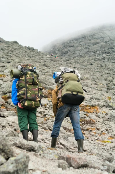 Dois mochileiros cansados em montanhas com mochilas — Fotografia de Stock
