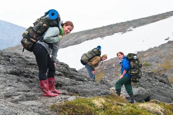 Tired team of backpackers in mountains with knapsacks — Stock Photo, Image