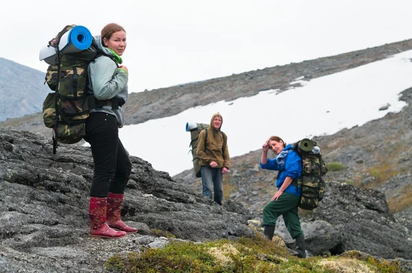 Tired team of backpackers in mountains with knapsacks — Stock Photo, Image