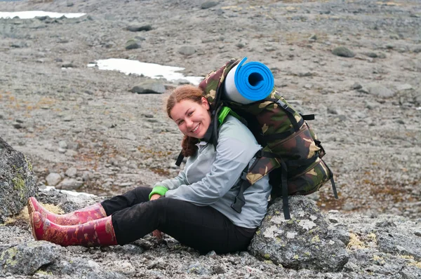 Backpacker μια νεαρή γυναίκα που κάθεται πάνω σε βράχο στα βουνά — Φωτογραφία Αρχείου