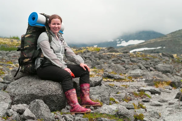 Backpacker una giovane donna seduta sulla roccia in montagna — Foto Stock