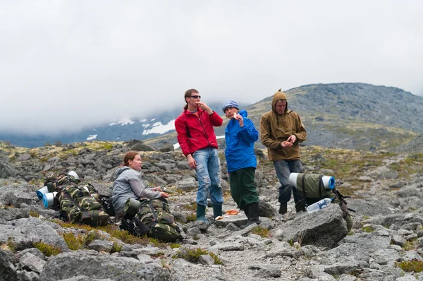 Группа путешественников в горах с рюкзаками отдыхают — стоковое фото