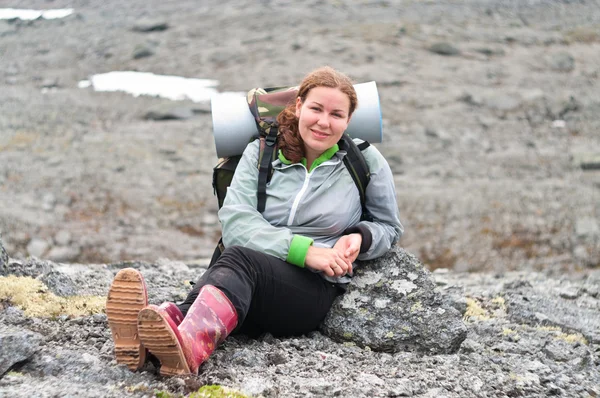 バックパッカー山の岩の上に座っている若い女性 — ストック写真