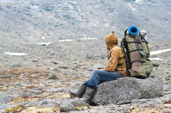 백 패 커 수석 남자 산에서 바위에 앉아 — 스톡 사진