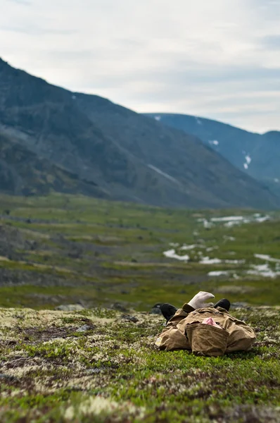 पहाड़ों में घास पर आराम करने वाला आदमी — स्टॉक फ़ोटो, इमेज