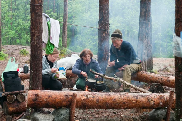 Туристы готовят на огне в лесу — стоковое фото