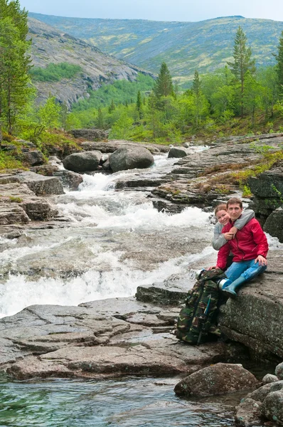 Couple embrace by the rapid mountain river — Stock Photo, Image