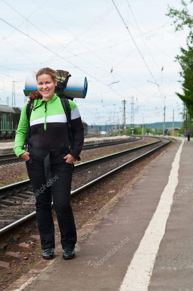 Backpacker a young woman waiting train on railway station