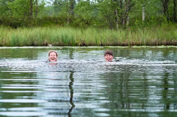 Две плавающие молодые женщины в речной воде — стоковое фото