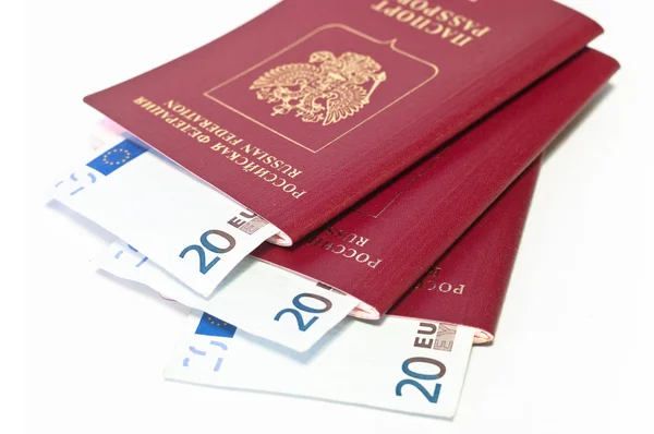 Куча красных паспортов и евро наличными небольшие банкноты на белом — стоковое фото