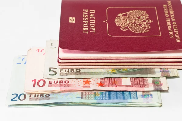 stock image Pile of red passports and euro cash small banknotes on white