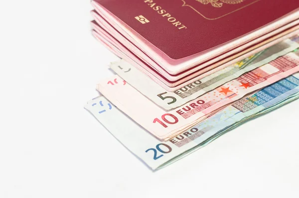 stock image Pile of red passports and euro cash small banknotes on white