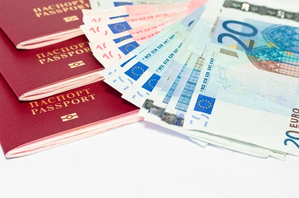 stock image Pile of red passports and euro cash small banknotes on white