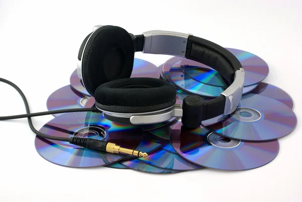 Beyaz arka planda cd diskler üzerinde kulaklık — Stok fotoğraf