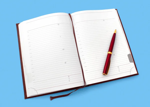 Cuaderno diario abierto con bolígrafo aislado sobre fondo cian —  Fotos de Stock