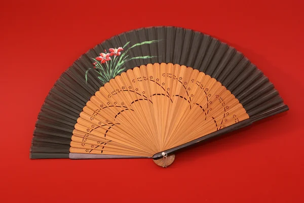 East traditional fan isolated on red background — Stock Photo, Image