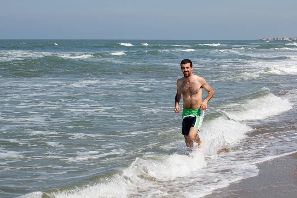Mężczyzna gra na plaży — Zdjęcie stockowe