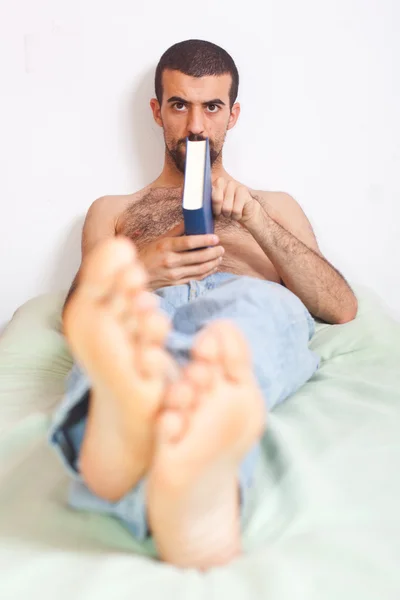 Hombre leyendo un libro en la cama —  Fotos de Stock